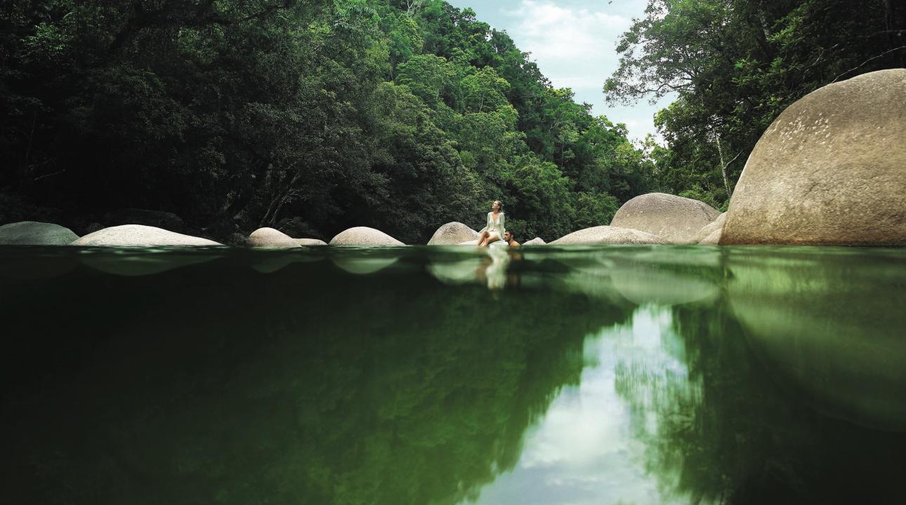 couple sitting on the rocks by a river