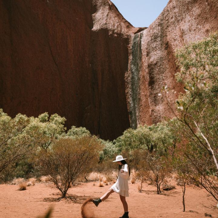 Woman kicking up the red dust from the earth