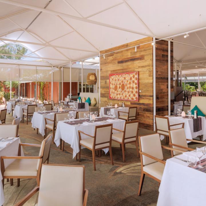 A widespan image of the Arnguli Grill Restaurant with a beautiful indigenous painting in the background.