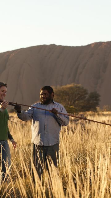 A man and a guide looking at a spear