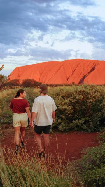 Couple walking in front of Uluru