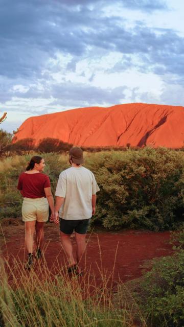 Couple walking in front of Uluru