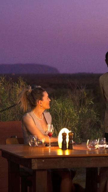 A couple dining at Tali Wiru at Ayers Rock Resort, in front of Uluru