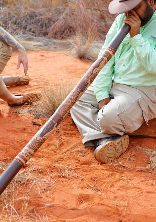 Didgeridoo being played by man in the outback